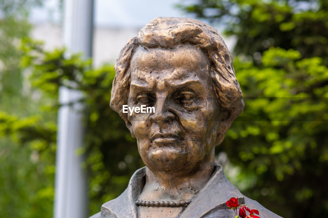 CLOSE-UP OF STATUE AGAINST BLURRED BACKGROUND