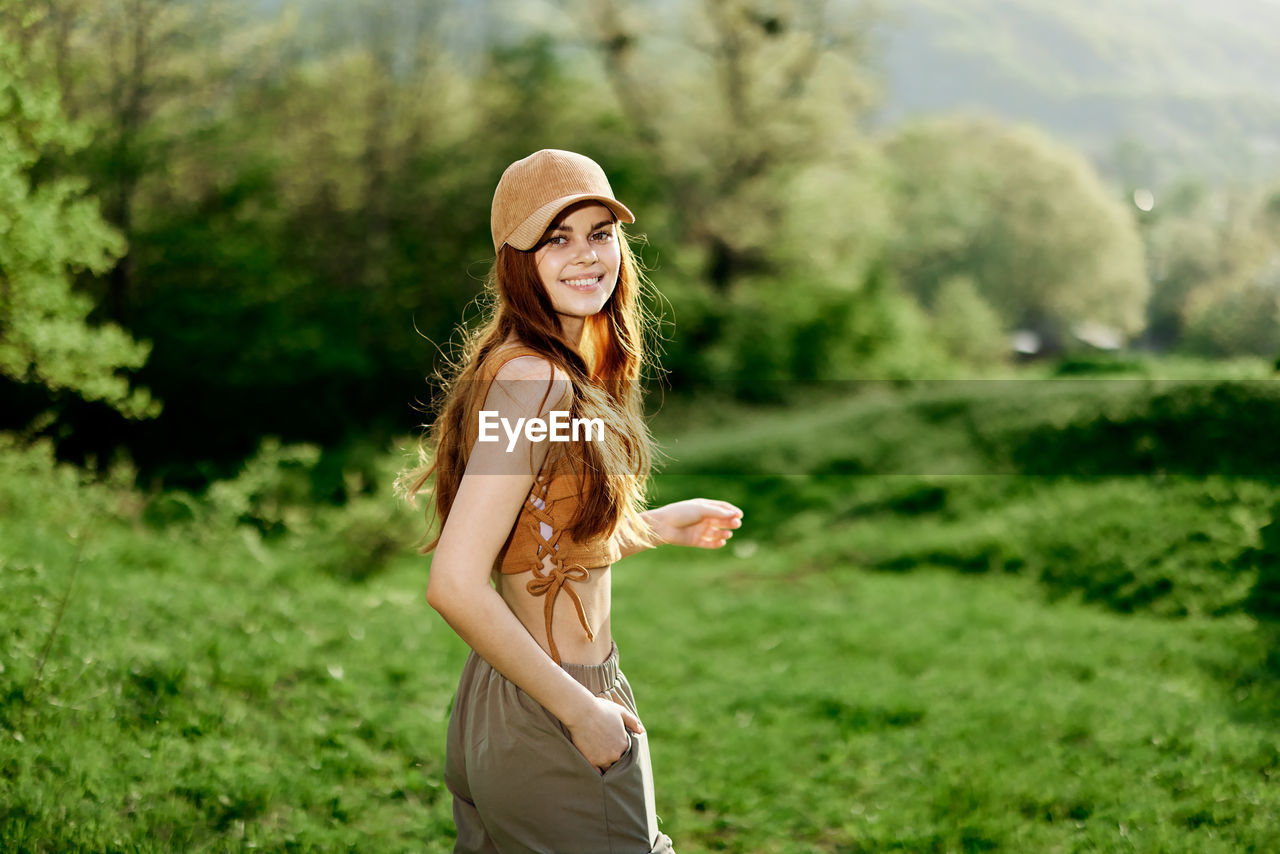 side view of young woman standing on field