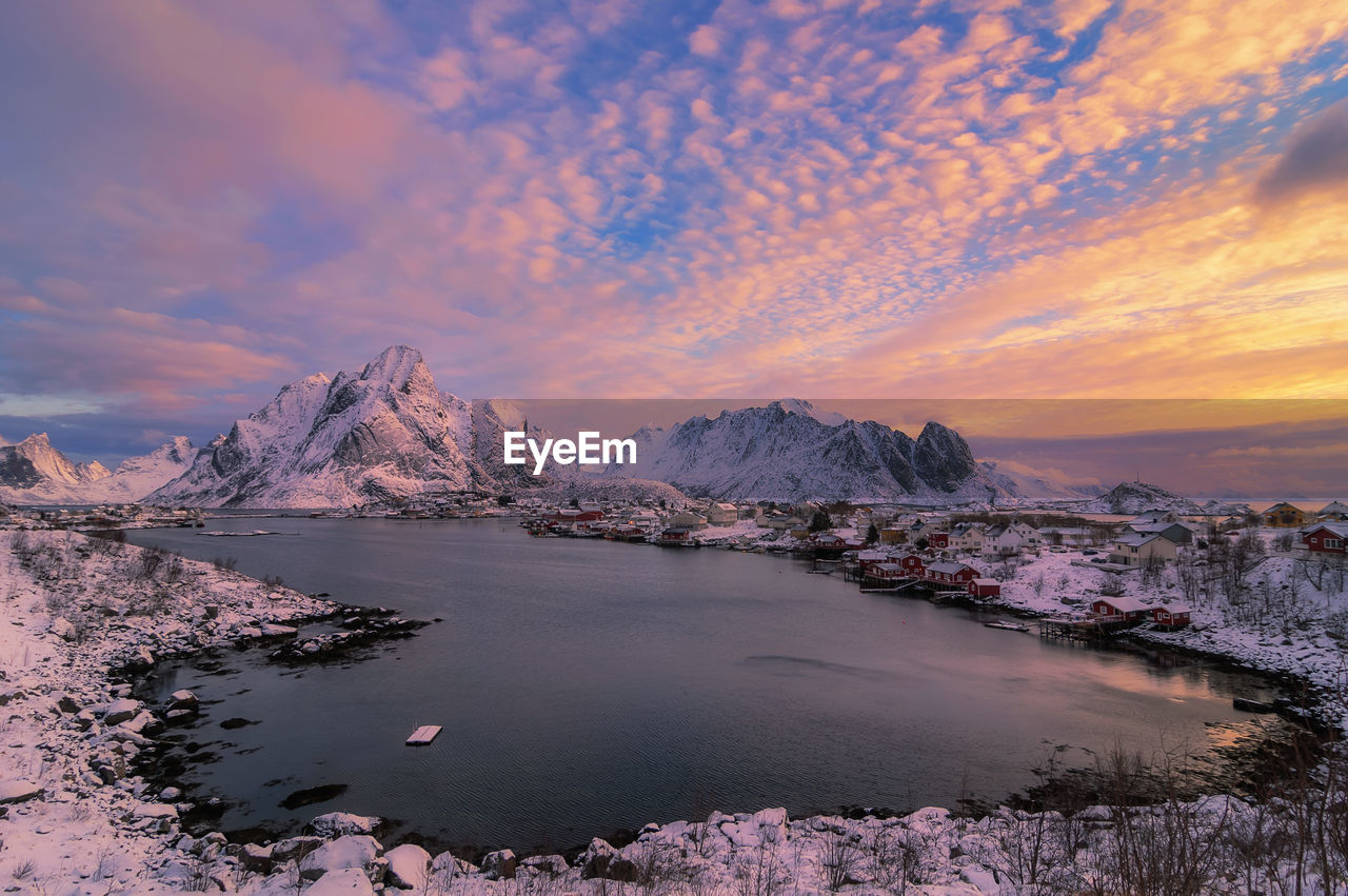 Scenic view of lake by mountains against sky during sunset norway