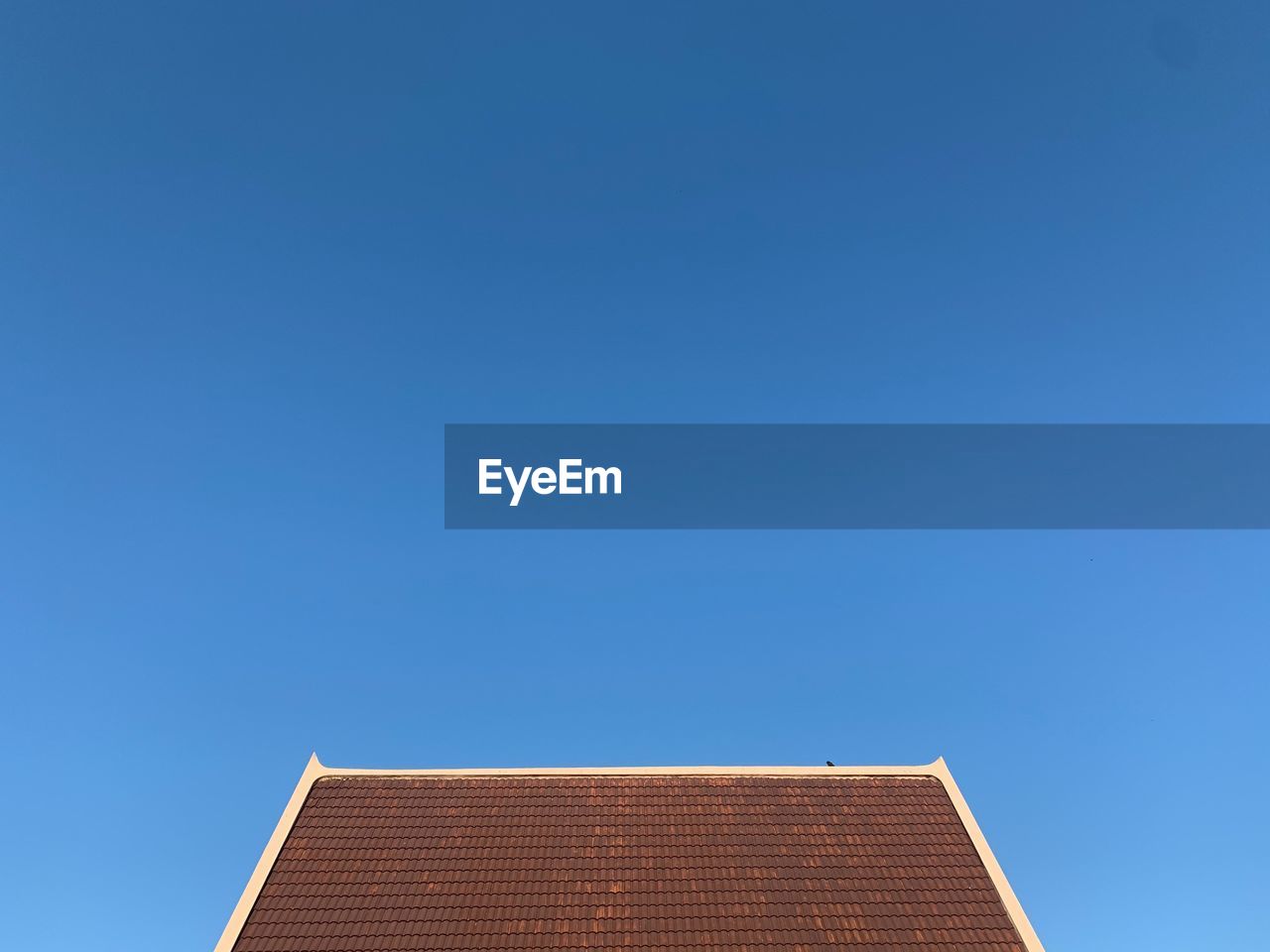 LOW ANGLE VIEW OF BUILDING ROOF AGAINST CLEAR SKY