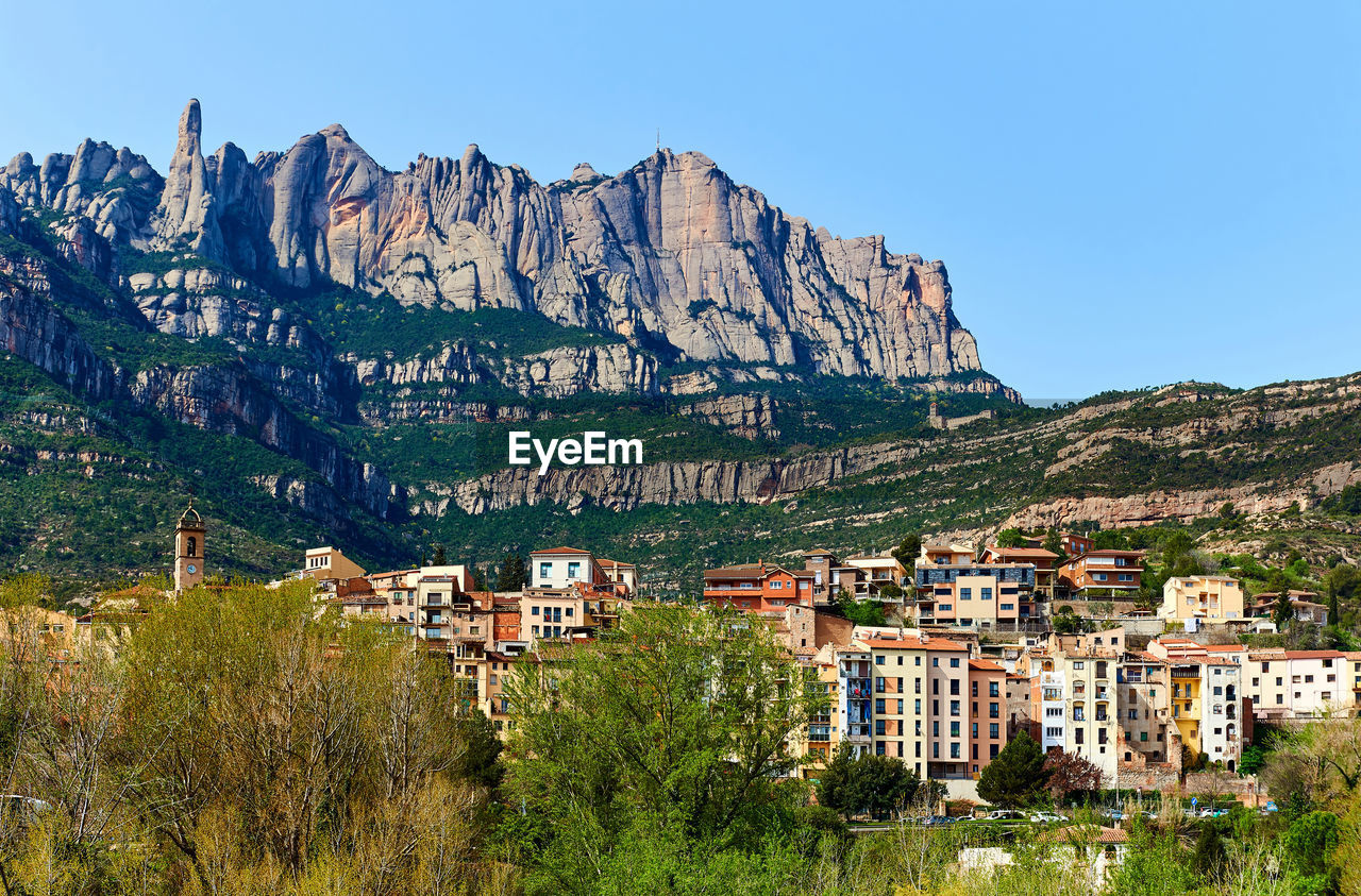 Scenic view of town against montserrat mountains against clear sky