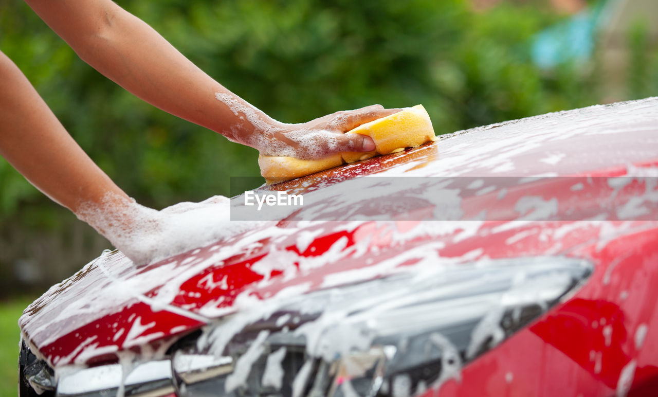 Cropped image of hand washing car