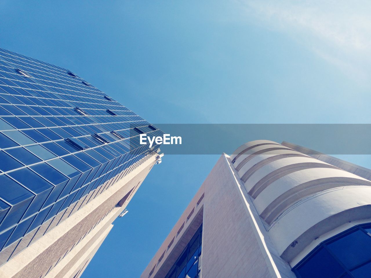 Low angle view of modern buildings against clear blue sky