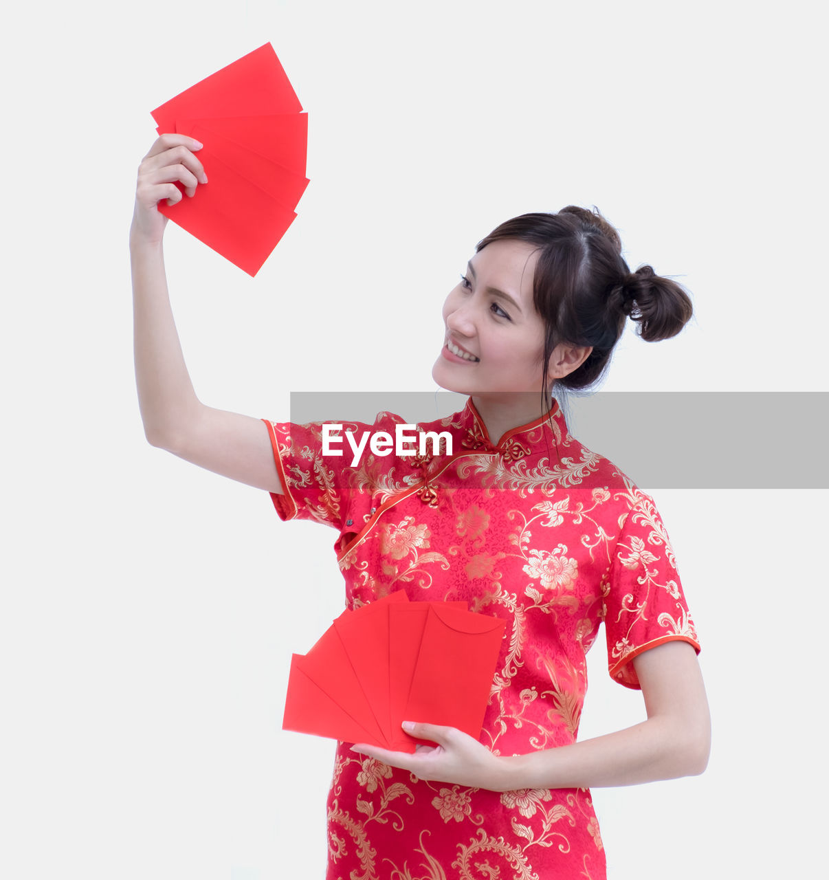 Smiling woman holding envelopes against white background