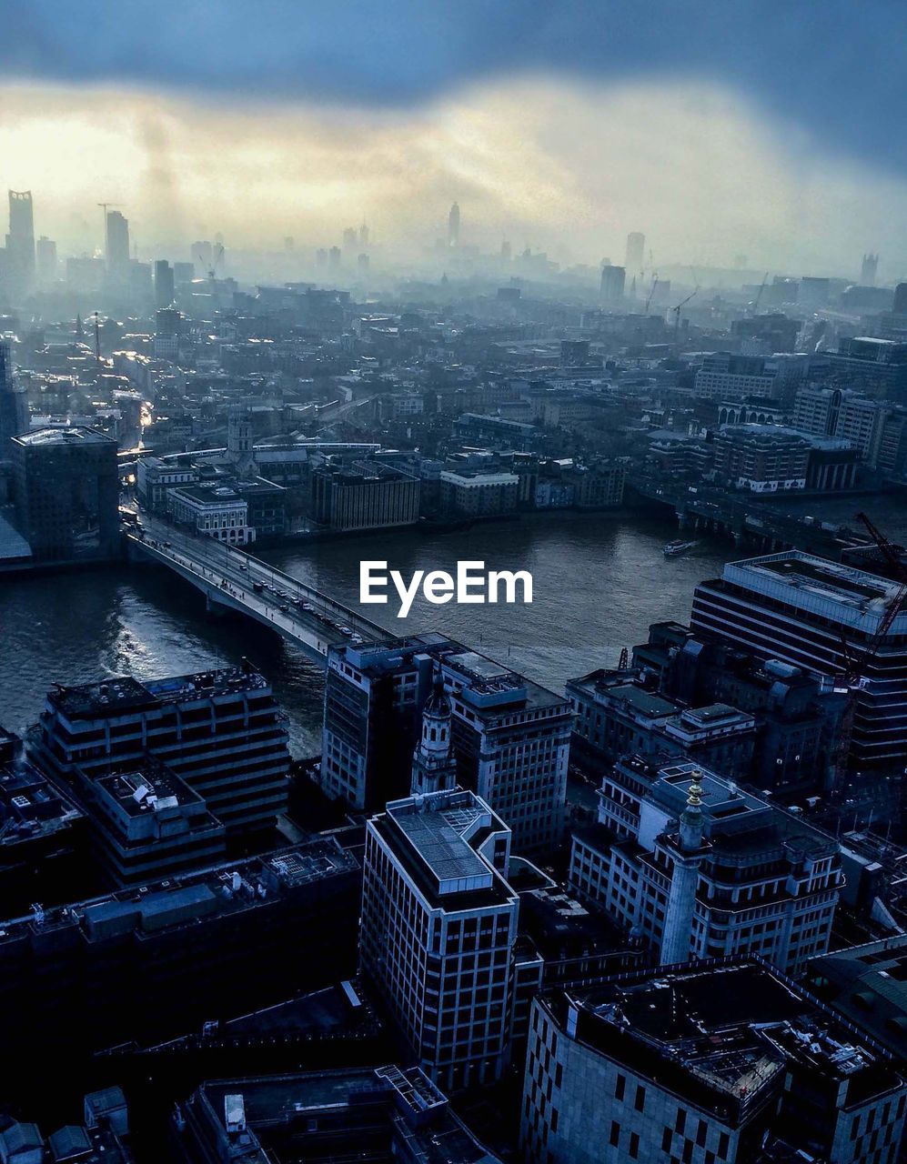 HIGH ANGLE VIEW OF CITYSCAPE AGAINST CLOUDY SKY