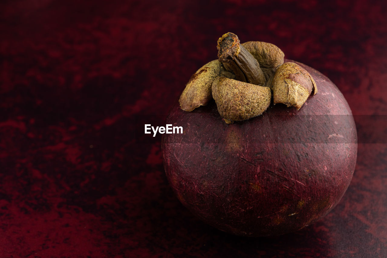 Closeup of mangosteen fruit on red background