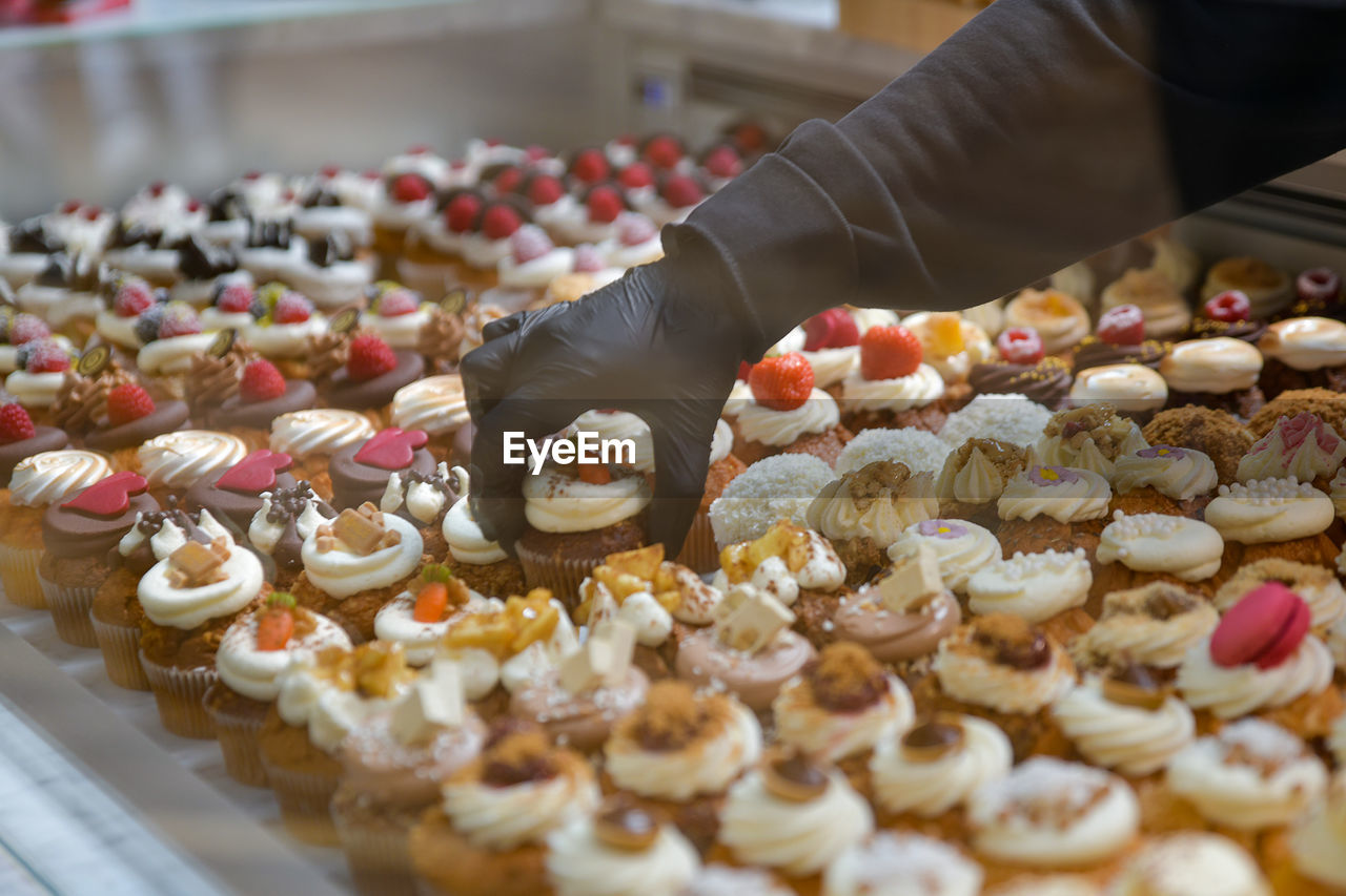 Confectioner placing cakes on a showcase for sale