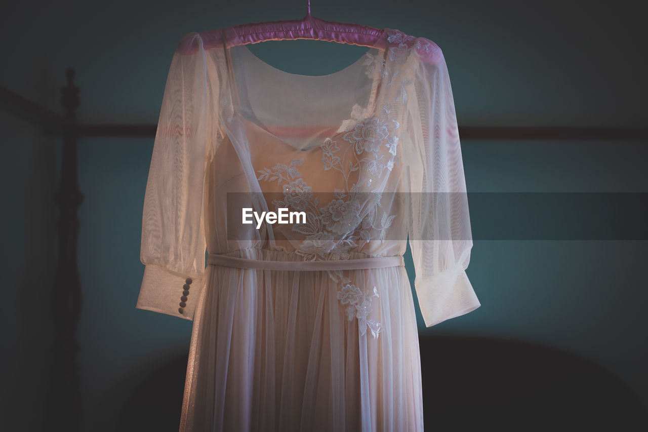 Wedding dress standing against the wall before the ceremony 