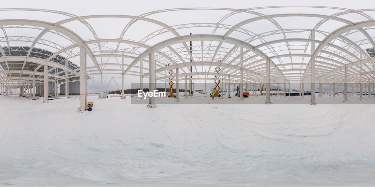 Spherical 360 by 180 degree panorama of winter outdoor factory building process, equirectangular