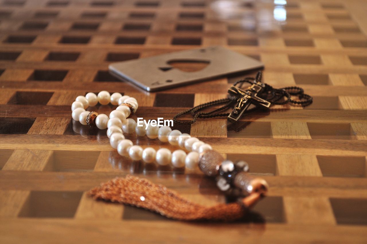 Close-up of tasbih and rosary on floor