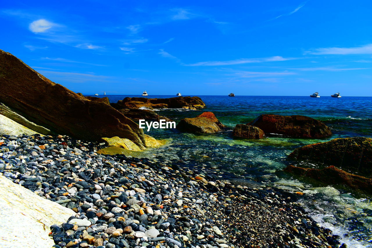 ROCKS ON BEACH AGAINST SKY