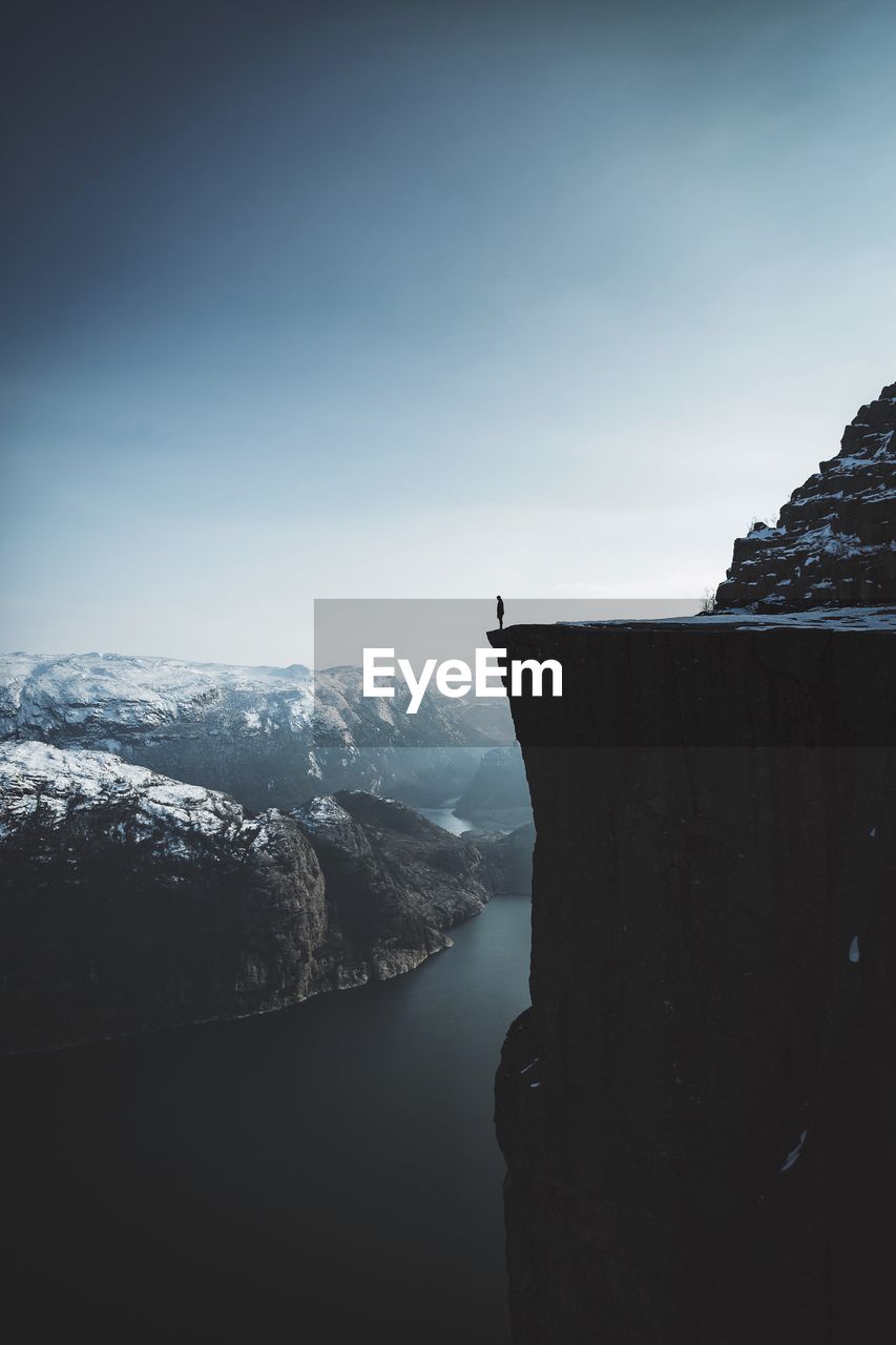 Scenic view of inlet amidst mountain against sky during winter