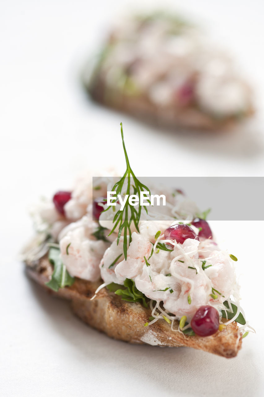 Shrimp and herb bruschetta on white background