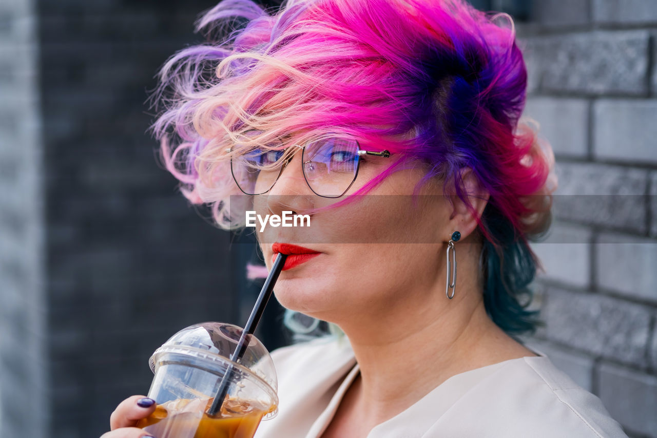 PORTRAIT OF WOMAN DRINKING FROM GLASS