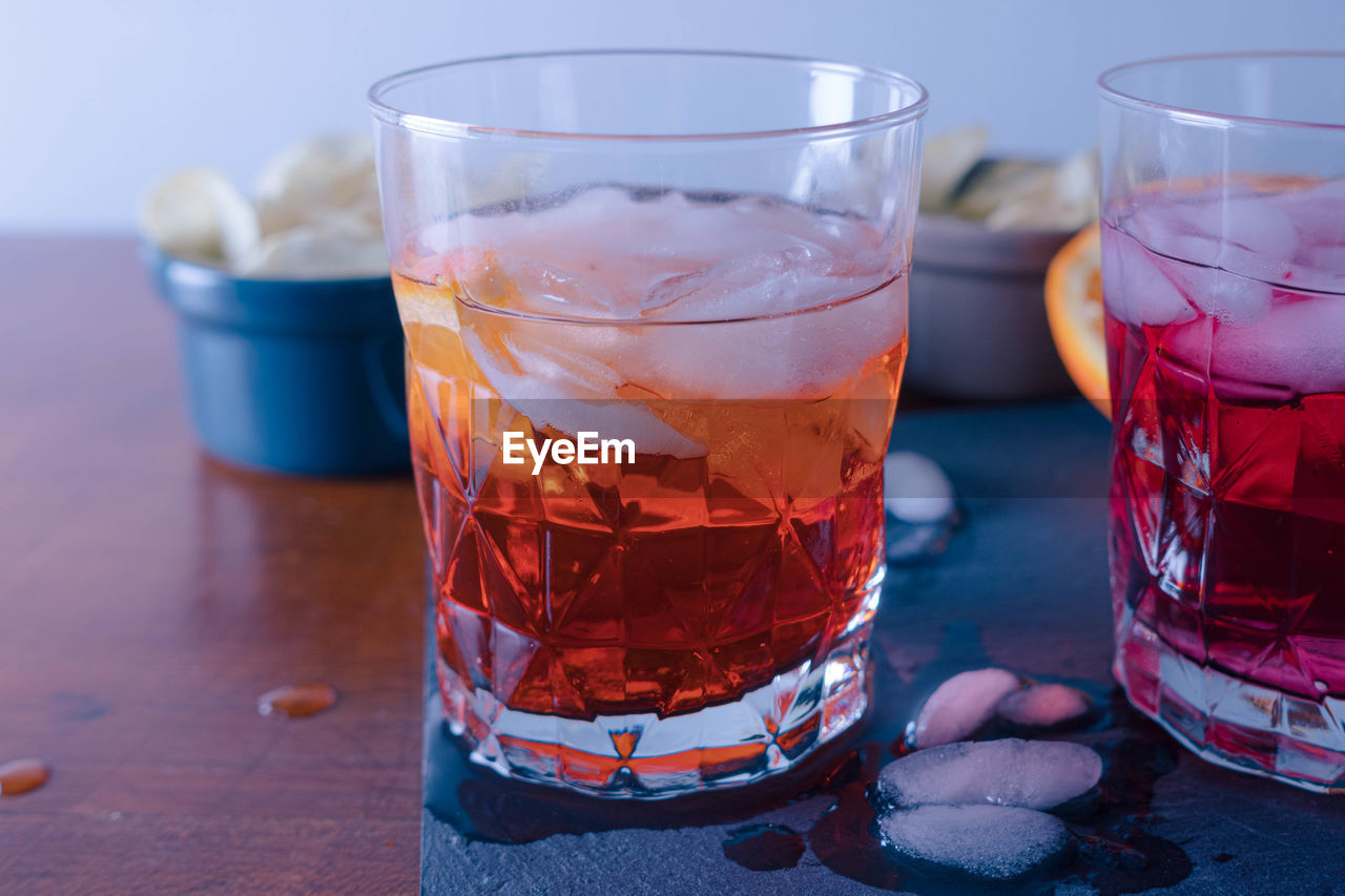 Two spritz with some chips on the table ready for the aperitif, the orangeone is mixed with aperol.