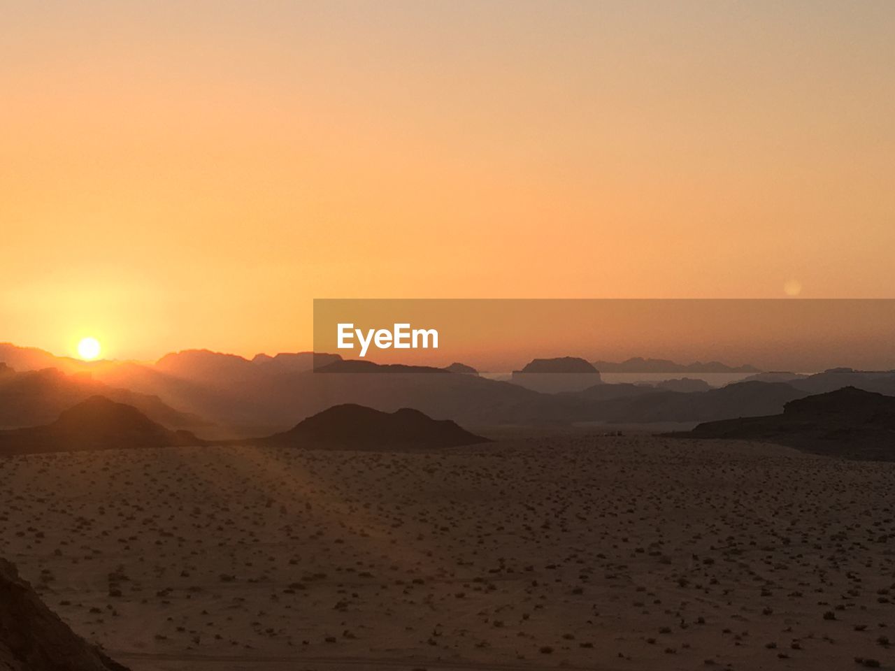 Scenic view of desert against sky during sunset