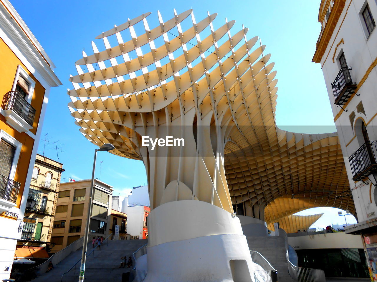 LOW ANGLE VIEW OF STREET AMIDST BUILDINGS AGAINST SKY