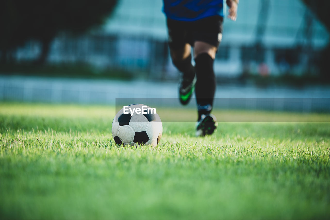 LOW SECTION OF MAN PLAYING SOCCER BALL