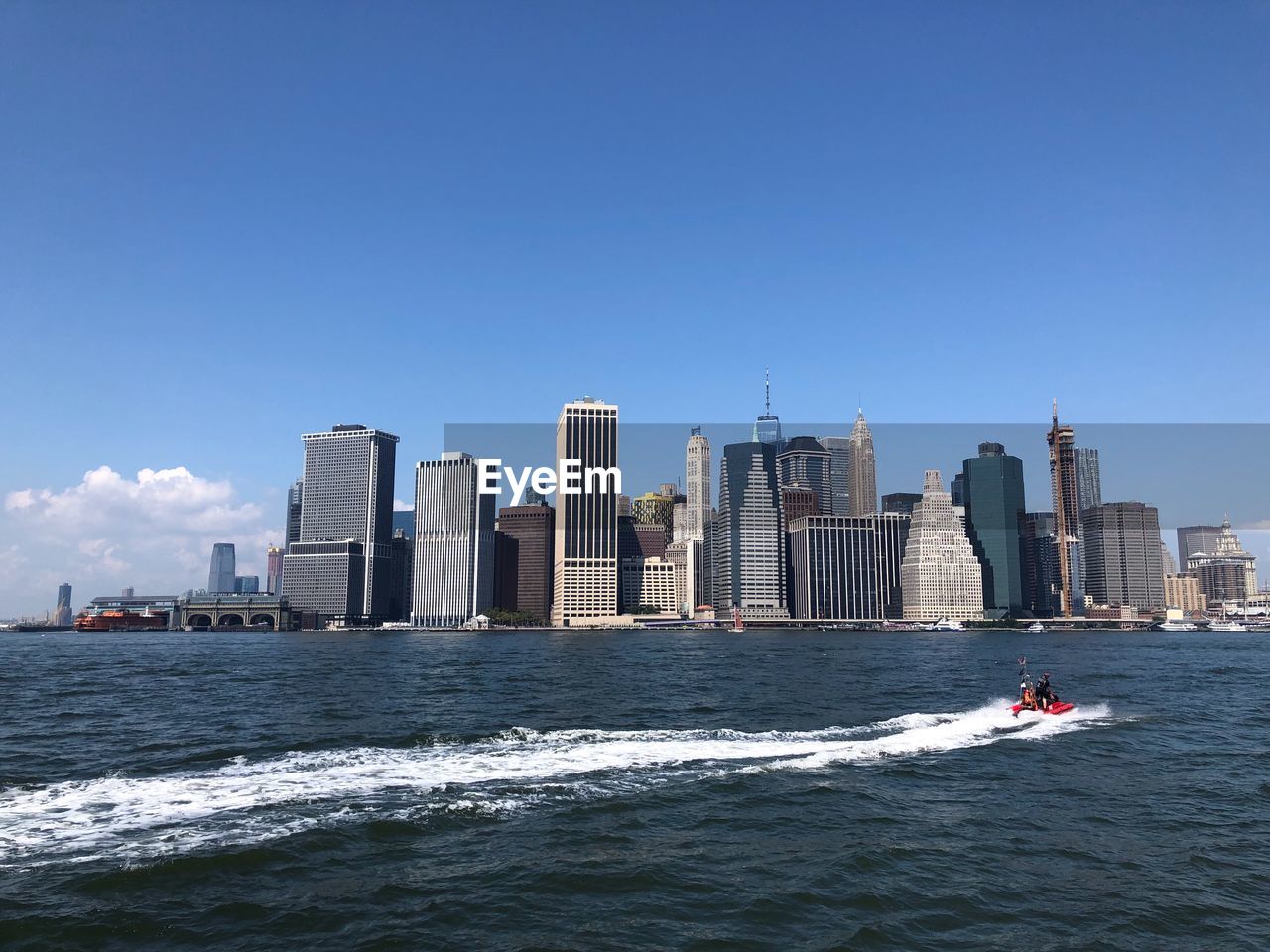 Modern buildings by sea against sky in city