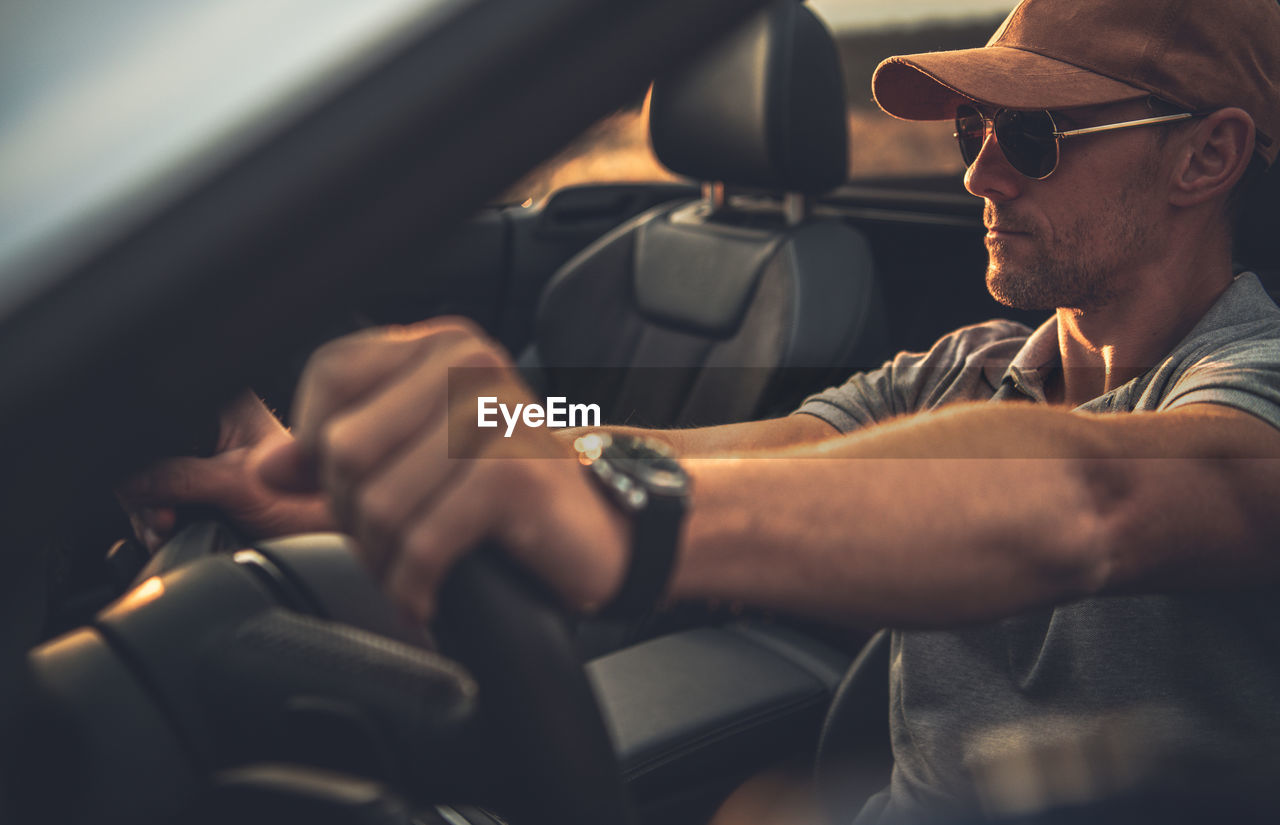 Mature man wearing sunglasses sitting in car