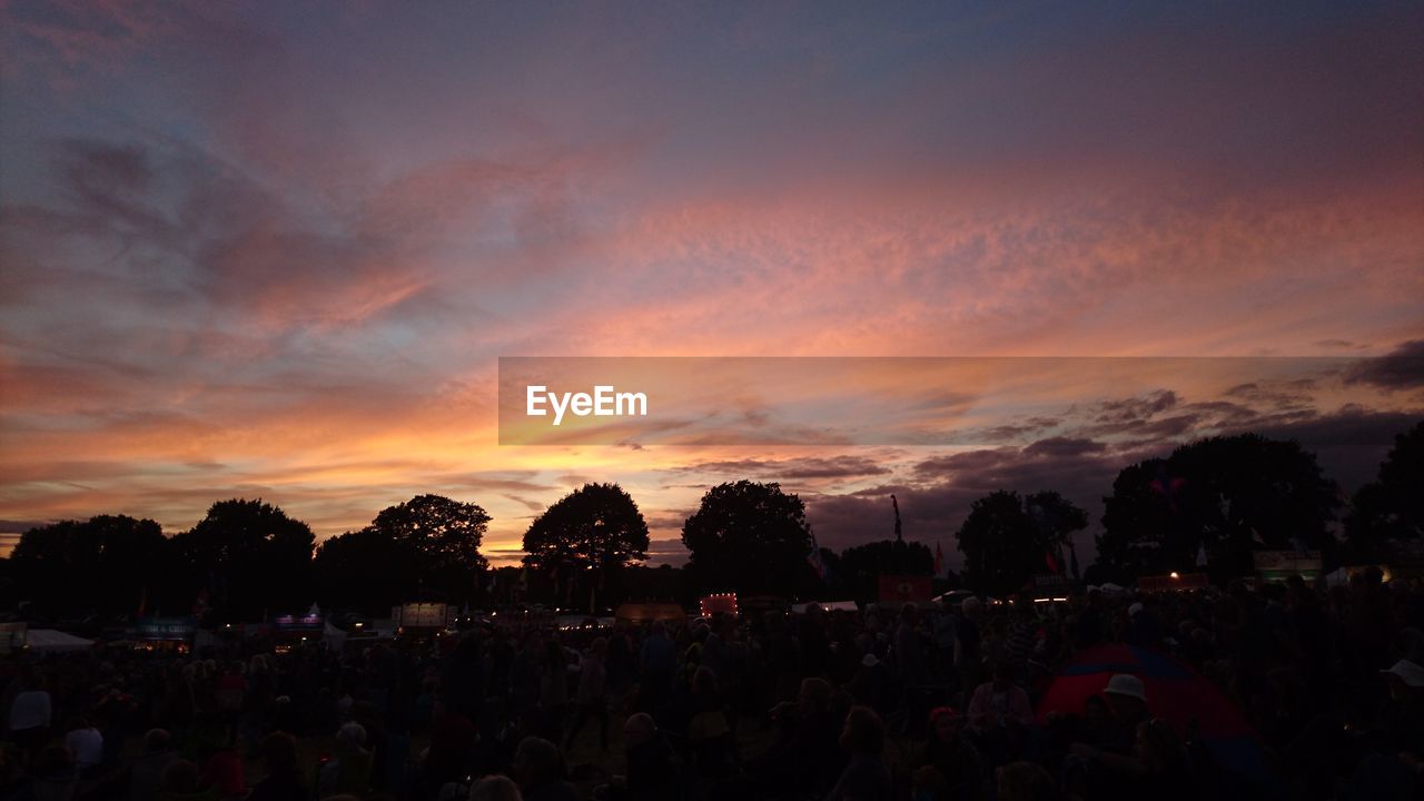 CROWD AGAINST SKY AT SUNSET