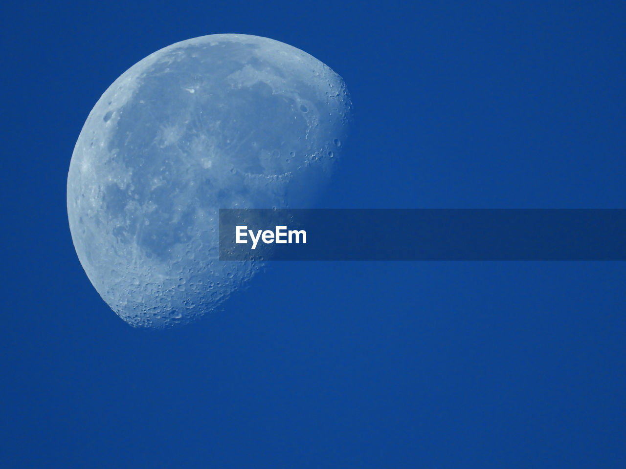 LOW ANGLE VIEW OF MOON AGAINST CLEAR BLUE SKY