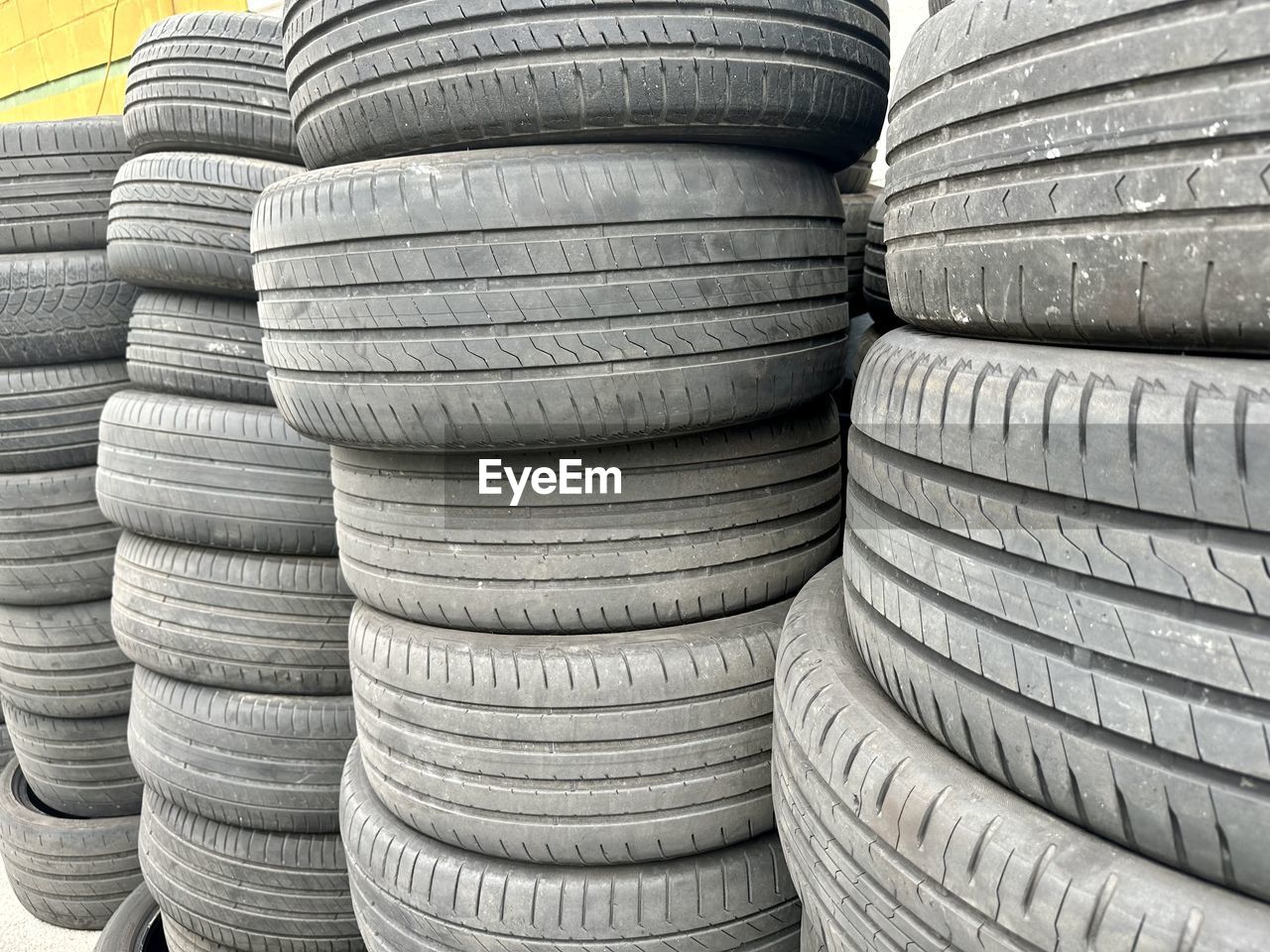 tire, automotive tire, synthetic rubber, rubber, tread, large group of objects, wheel, natural rubber, no people, pattern, arrangement, full frame, backgrounds, industry, day, abundance, close-up, in a row, repetition, order, still life