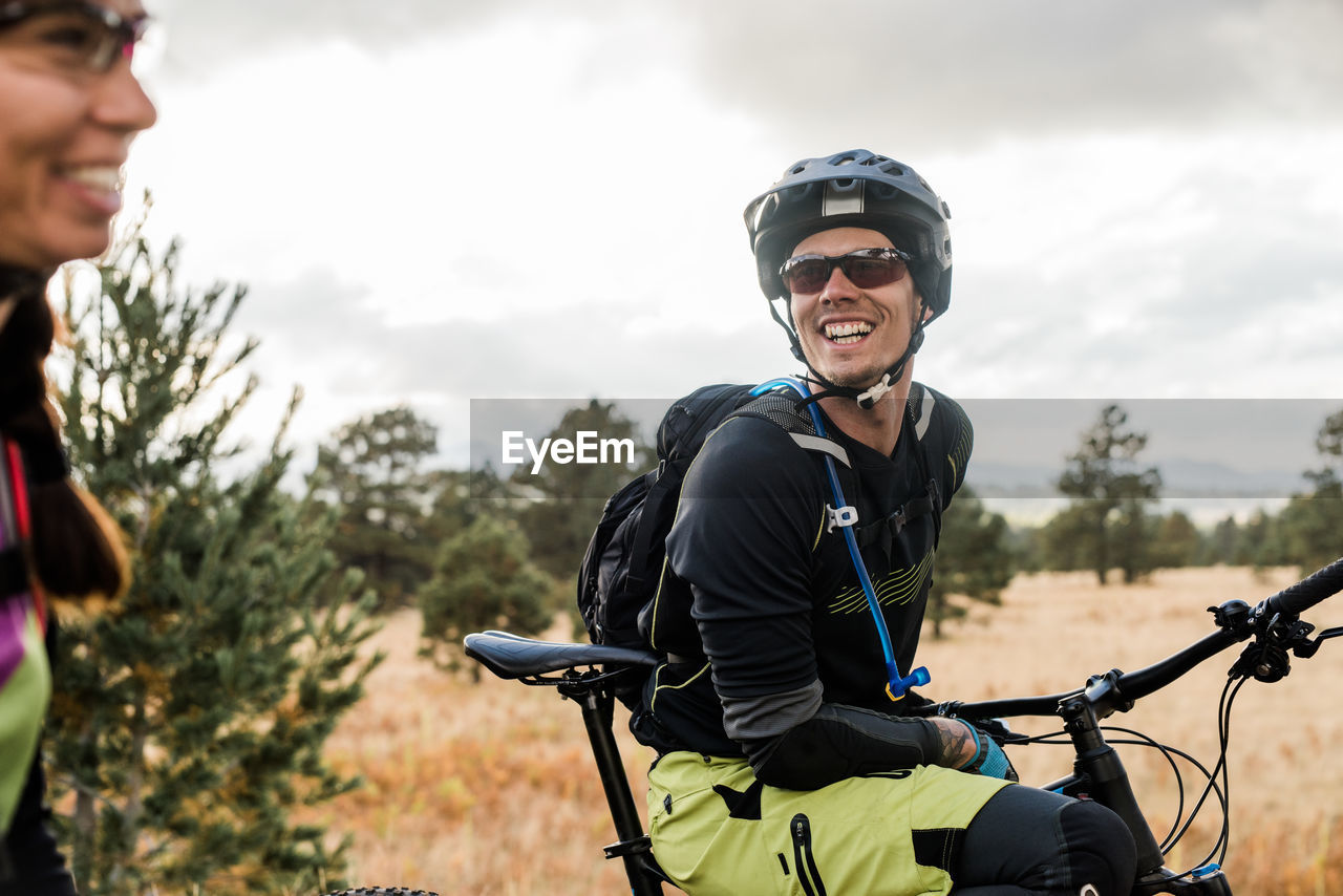 Lauging male mountain biker in meadow