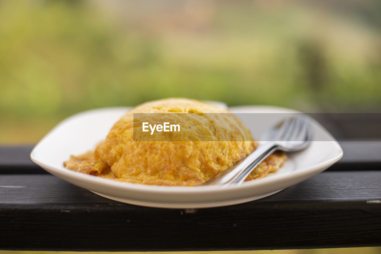 Close-up of fried egg with spoon and fork