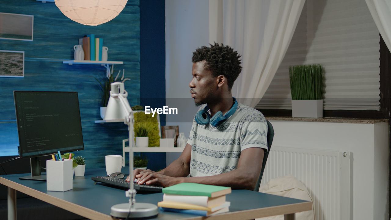 Young man using computer by table