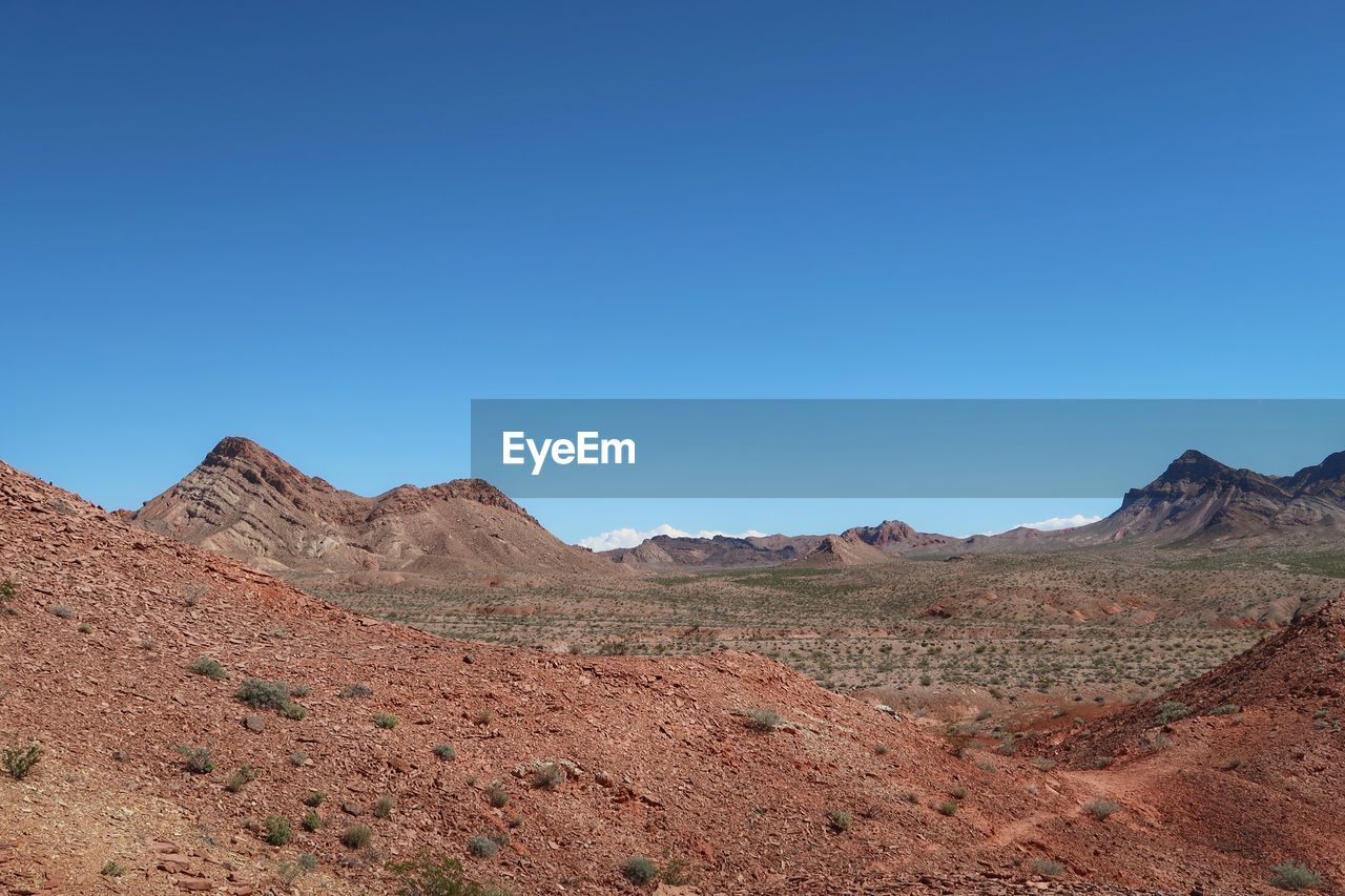 Scenic view of mountains against clear blue sky