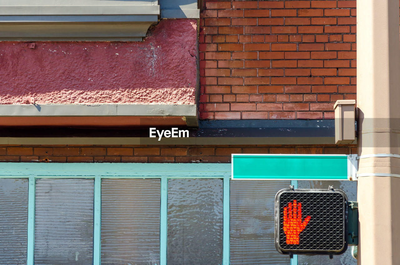 Stop signal on metallic pole against building in city