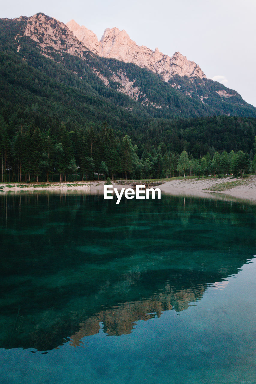 Scenic view of lake by mountains against sky