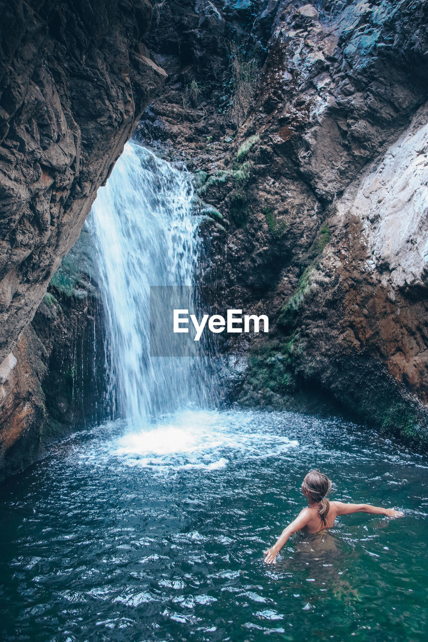 FULL LENGTH OF SHIRTLESS MAN STANDING ON ROCK