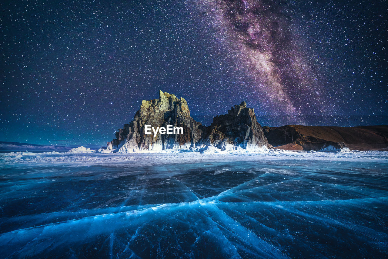 Scenic view of frozen lake against star field at night