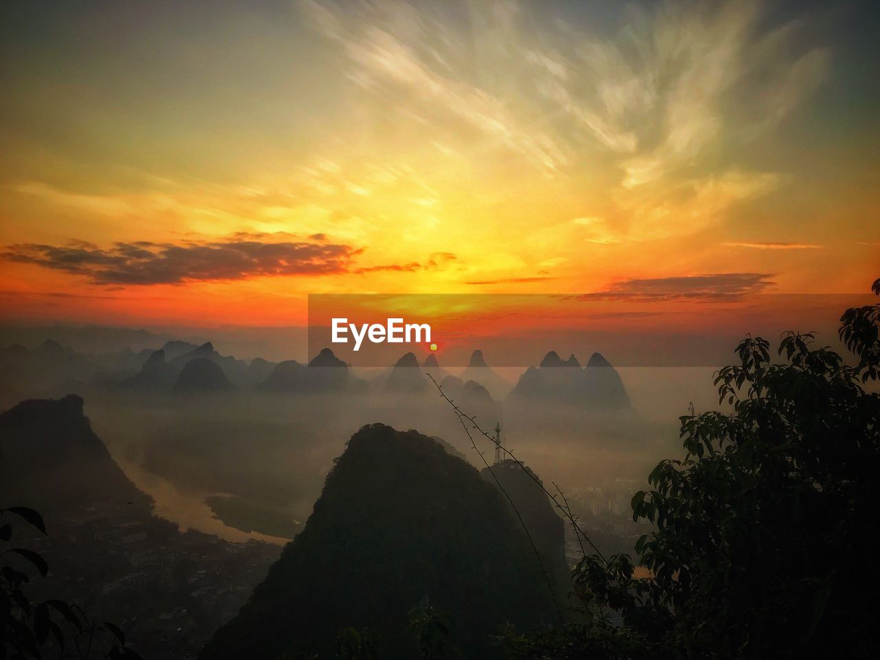 Scenic view of silhouette mountains against orange sky