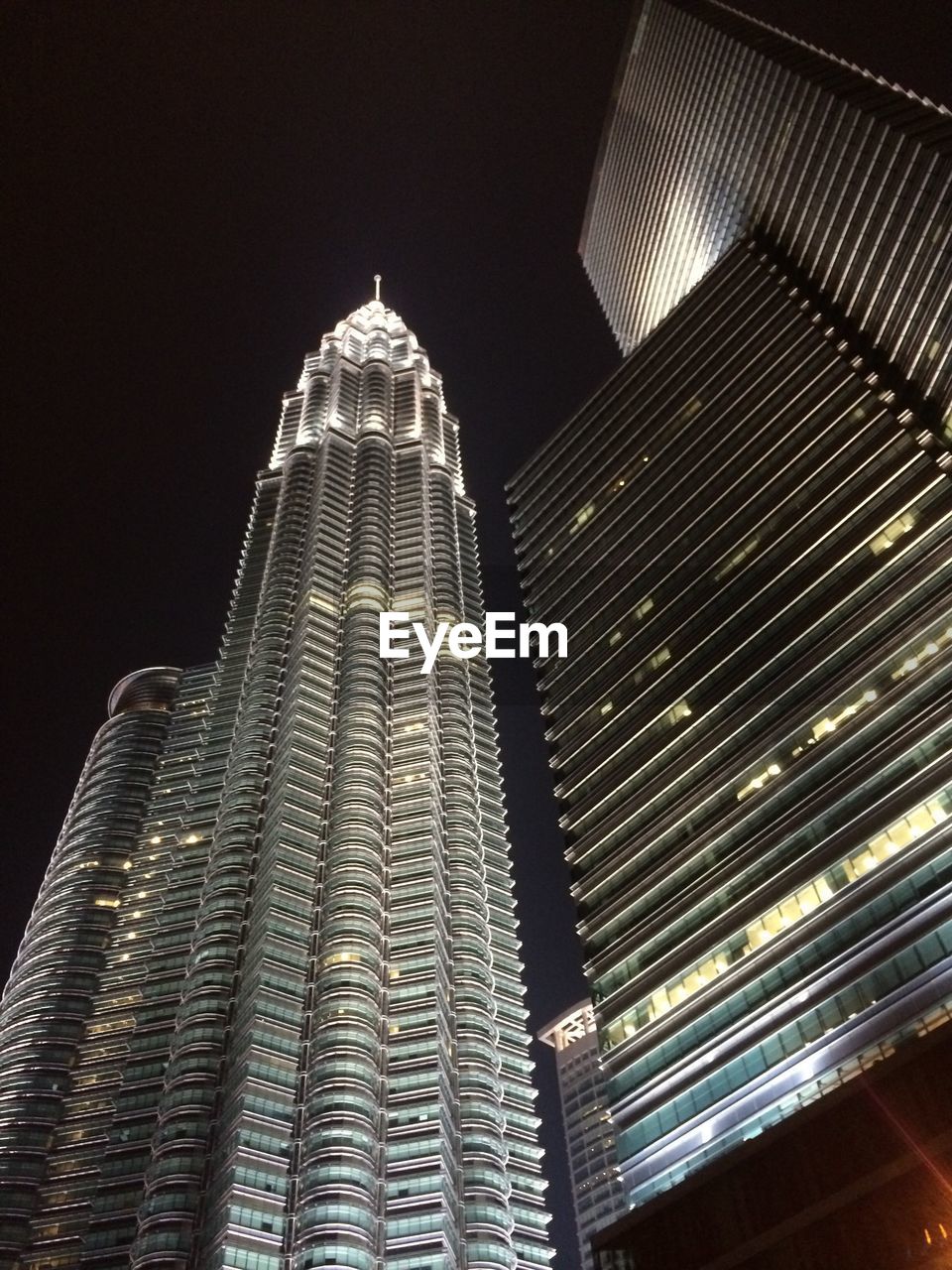 LOW ANGLE VIEW OF ILLUMINATED TOWER AT NIGHT