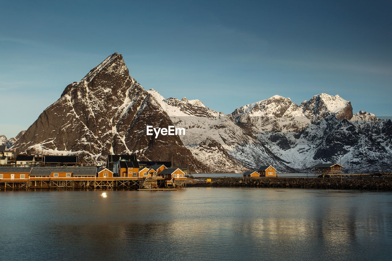 Scenic view of lake by snowcapped mountains against sky