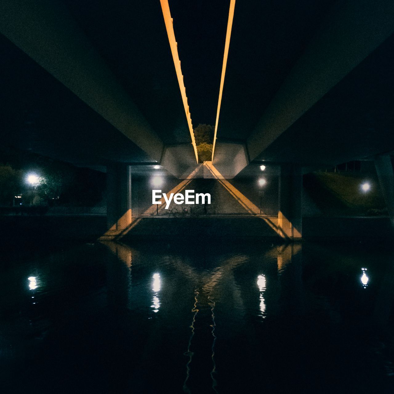 Symmetric lights under a highway by a stream