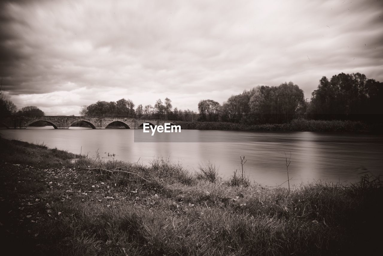 RIVER BY TREES AGAINST SKY