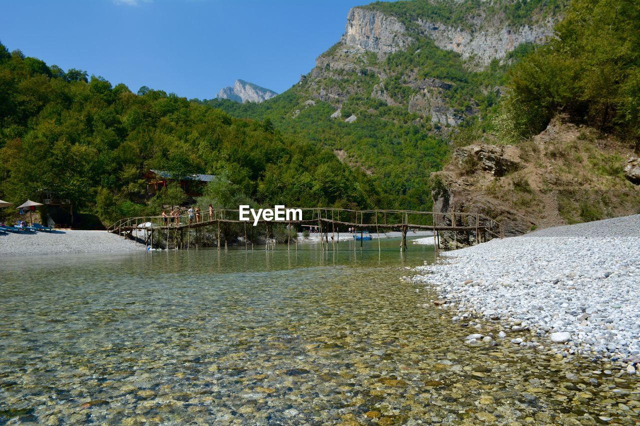 Scenic view of river by trees against sky