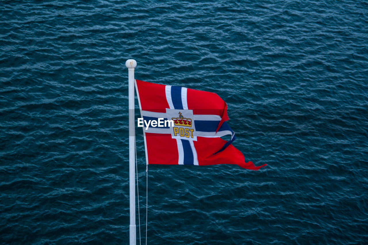 High angle view of norwegian flag waving against sea