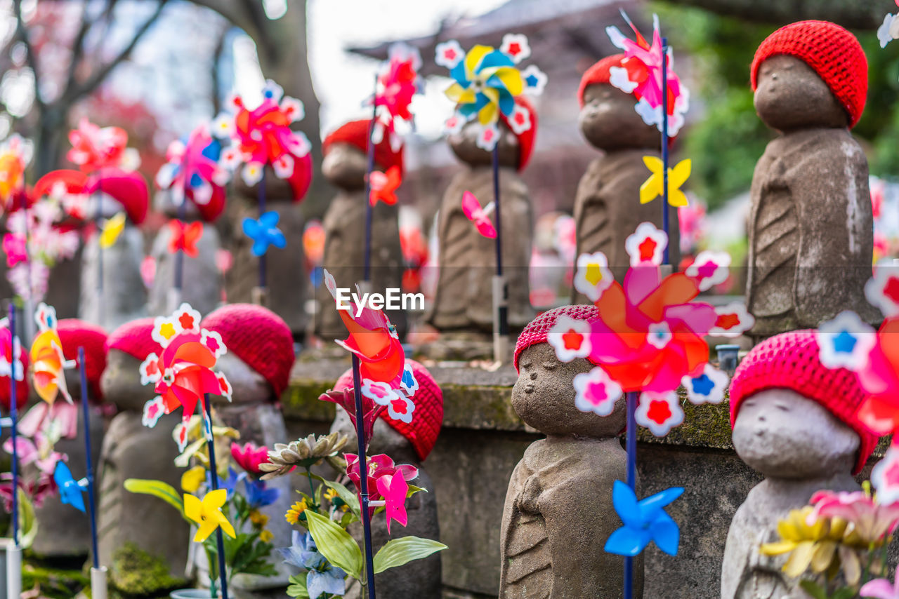 Close-up of statues by pinwheel toy in temple