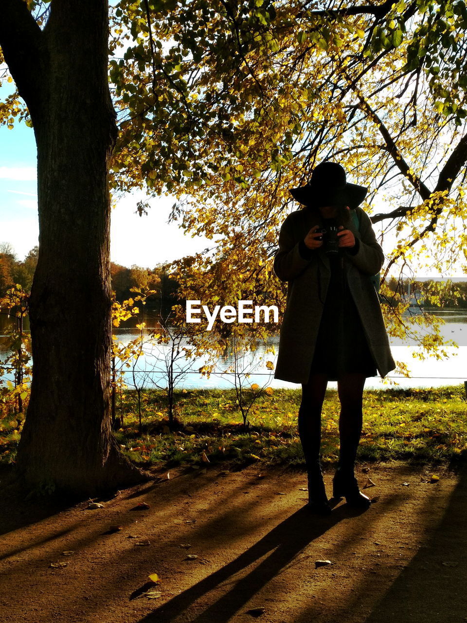 FULL LENGTH OF WOMAN STANDING BY TREES