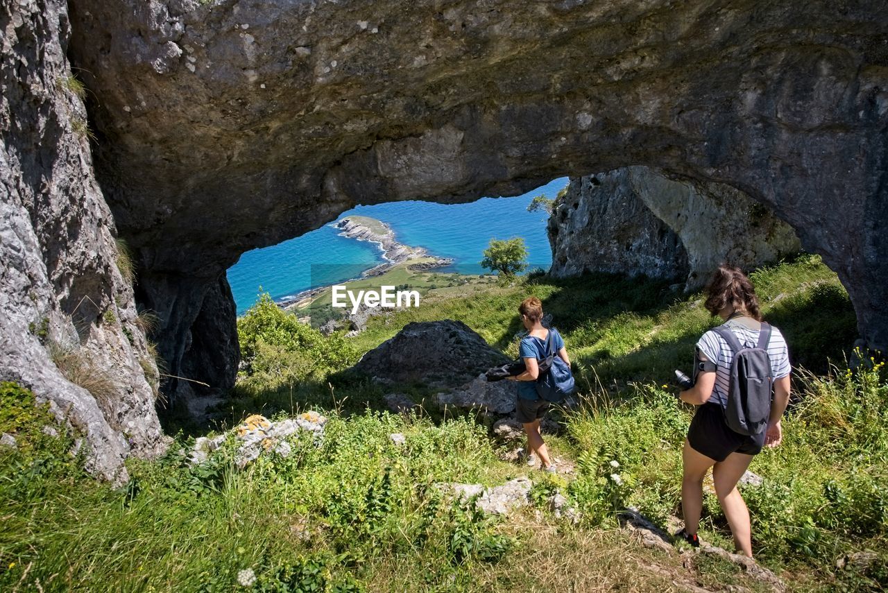 People standing on rock by mountain