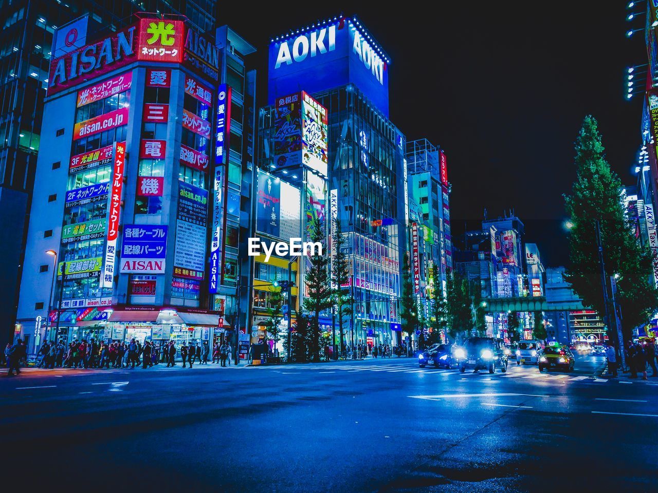 ILLUMINATED CITY STREET BY BUILDINGS AT NIGHT