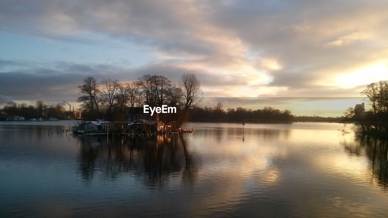 SILHOUETTE TREES BY LAKE AGAINST SKY