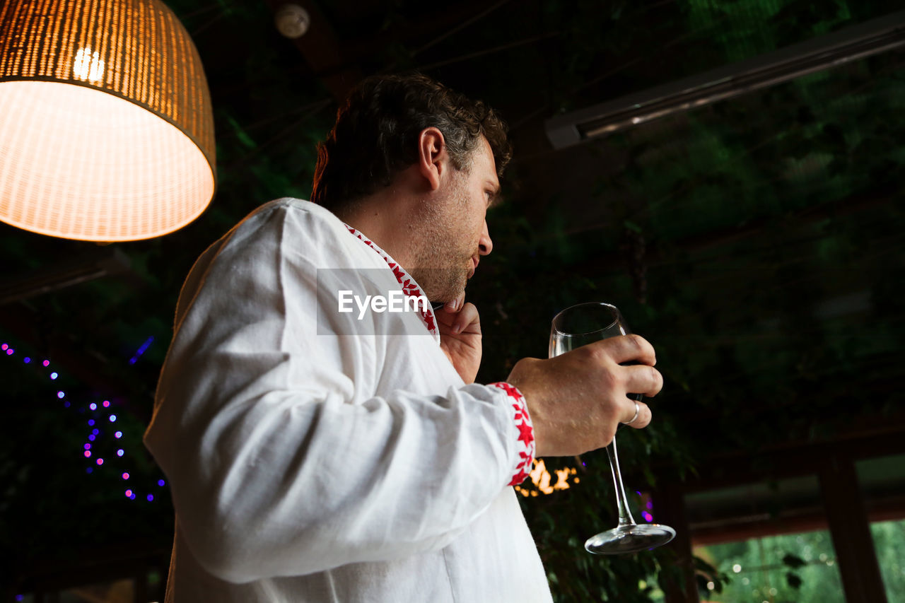 Man holding wineglass at night