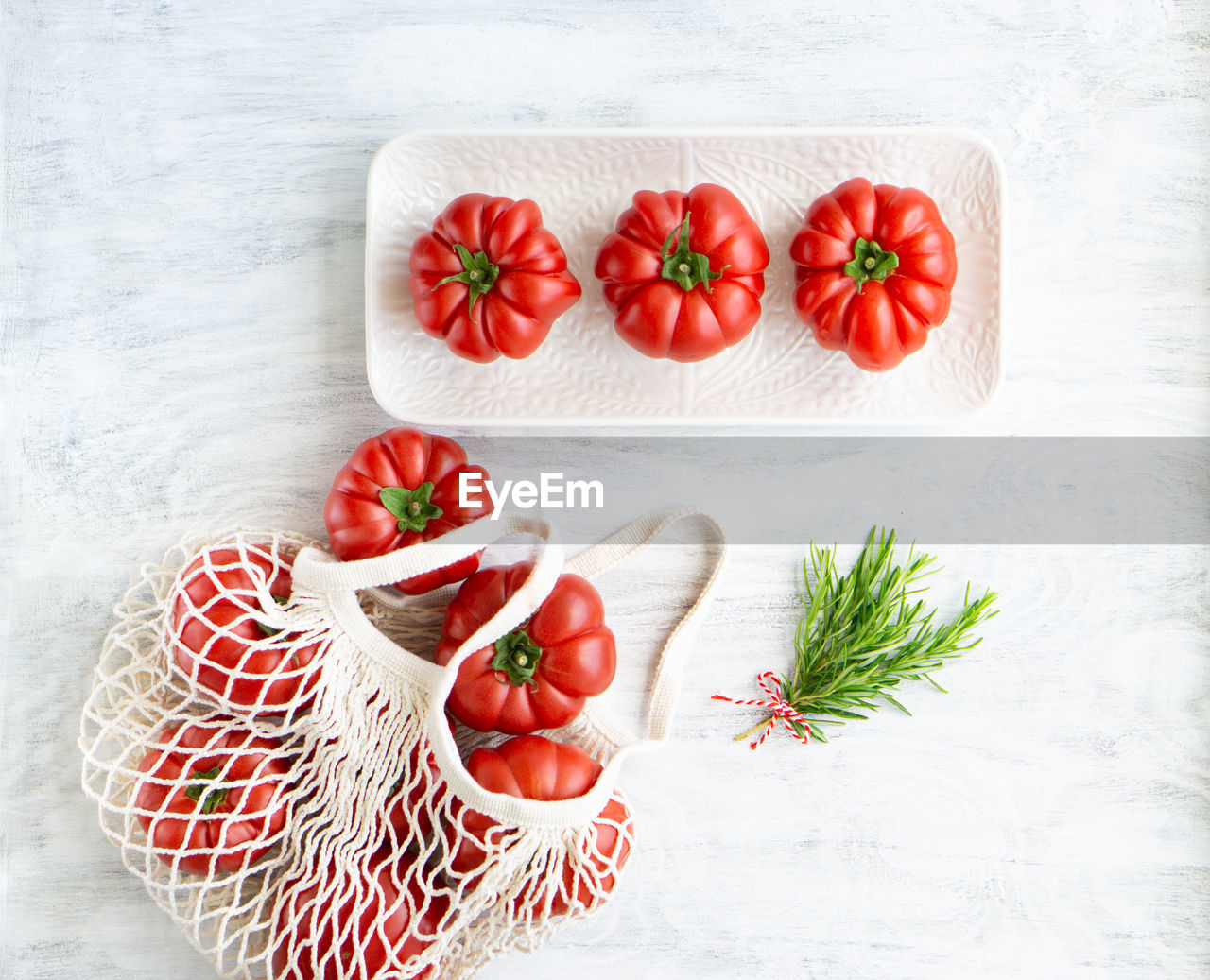 Still life of beautiful ripe tomatoes and rosemary.