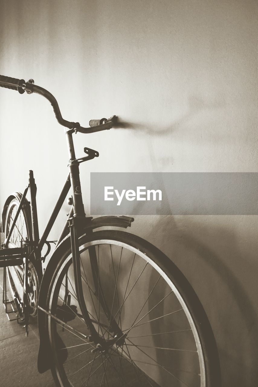 BICYCLE PARKED AGAINST WALL IN CITY